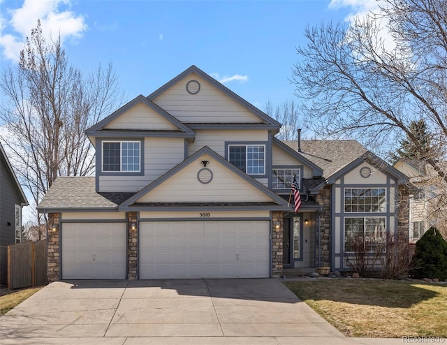 traditional home with concrete driveway, roof with shingles, fence, and stone siding