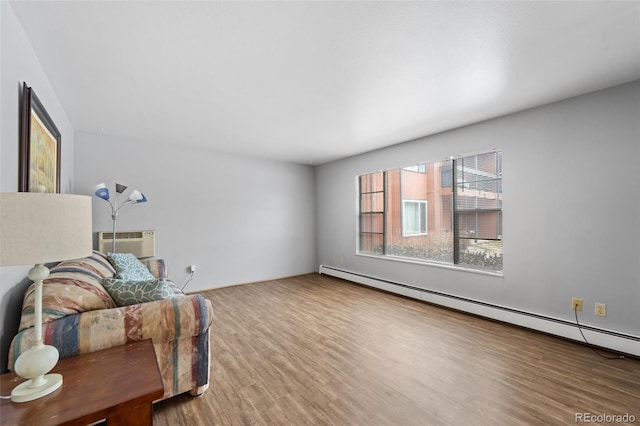 1625 W Elizabeth St Unit G2, Fort Collins, CO 80521 - sitting room featuring a baseboard radiator, wood finished floors, and a wall mounted air conditioner