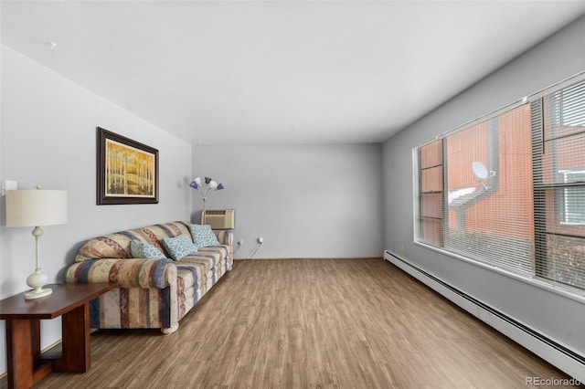 1625 W Elizabeth St Unit G2, Fort Collins, CO 80521 - living area featuring a baseboard radiator, wood finished floors, and an AC wall unit
