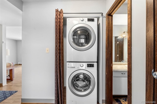 1625 W Elizabeth St Unit G2, Fort Collins, CO 80521 - laundry room featuring stacked washer / dryer and wood finished floors