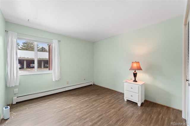 1625 W Elizabeth St Unit G2, Fort Collins, CO 80521 - unfurnished bedroom featuring a baseboard heating unit and wood finished floors