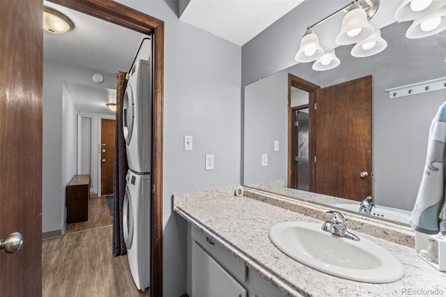 1625 W Elizabeth St Unit G2, Fort Collins, CO 80521 - bathroom featuring stacked washer / dryer, vanity, and wood finished floors