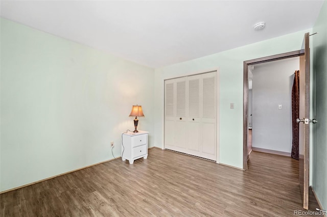 1625 W Elizabeth St Unit G2, Fort Collins, CO 80521 - unfurnished bedroom featuring wood finished floors and a closet