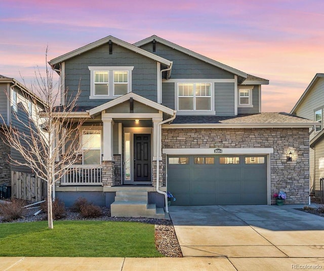 view of front of house featuring stone siding, concrete driveway, and a yard