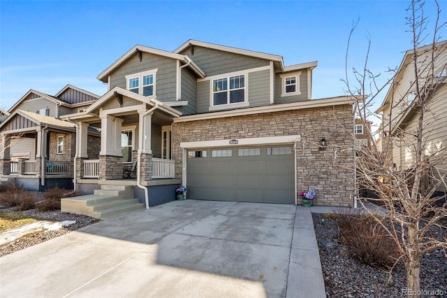 craftsman-style house with driveway, stone siding, an attached garage, and a porch