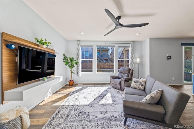 living room with a wealth of natural light, ceiling fan, baseboards, and wood finished floors