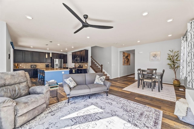 living area featuring dark wood finished floors, recessed lighting, a ceiling fan, baseboards, and stairs