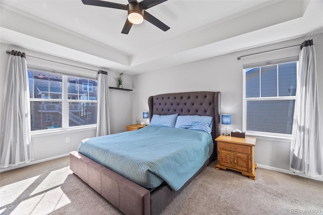 bedroom featuring carpet flooring, a raised ceiling, and baseboards