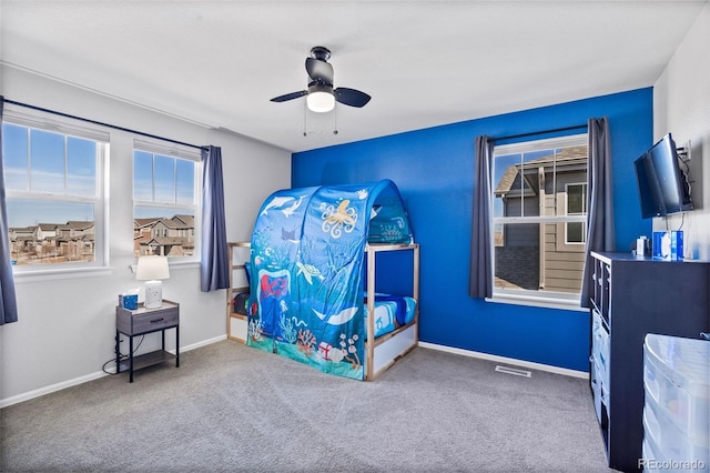 carpeted bedroom featuring a ceiling fan, visible vents, and baseboards