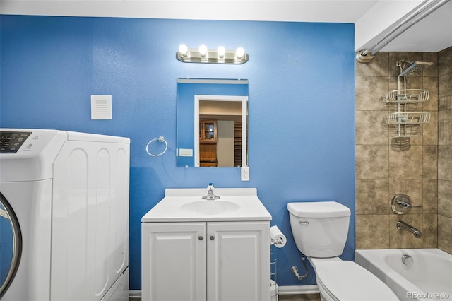 bathroom featuring shower / washtub combination, toilet, vanity, washer / dryer, and baseboards