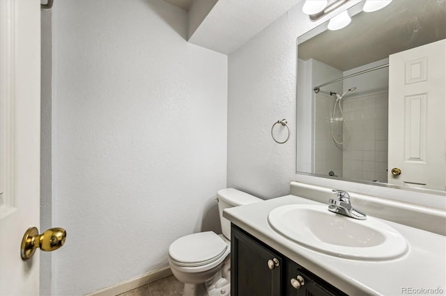 bathroom with tile patterned flooring, vanity, toilet, and walk in shower