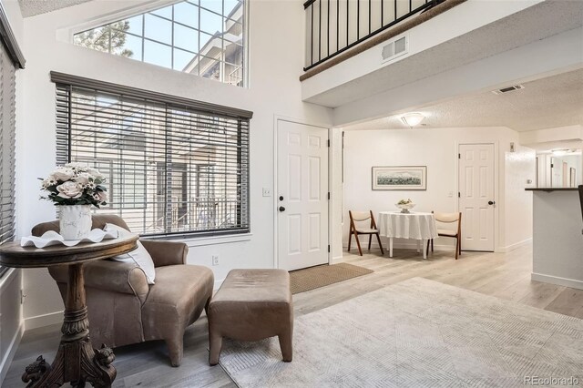 living area featuring wood finished floors, visible vents, and baseboards