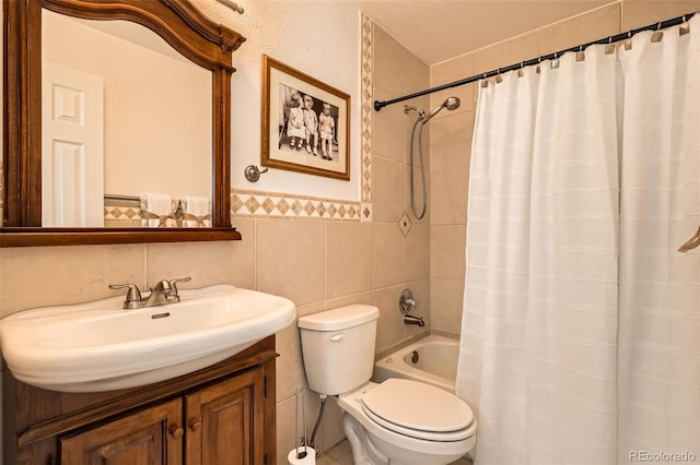 bathroom with toilet, a wainscoted wall, vanity, tile walls, and shower / bath combo with shower curtain