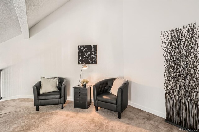 sitting room with lofted ceiling, carpet floors, a textured ceiling, and baseboards