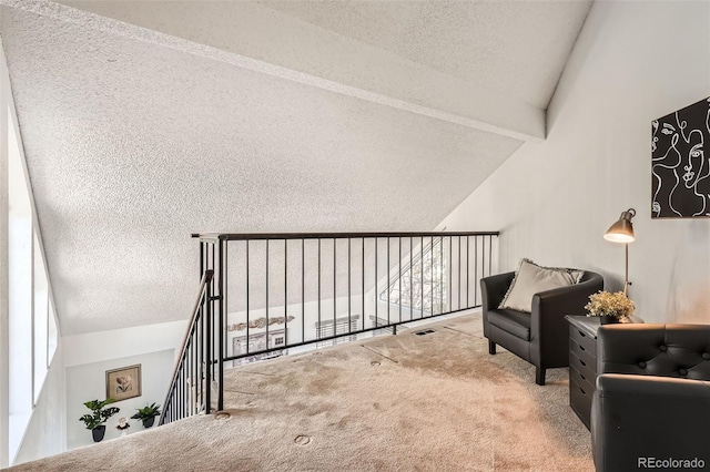 sitting room featuring visible vents, carpet flooring, lofted ceiling with beams, and a textured ceiling