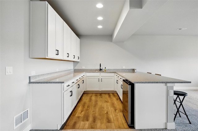 18212 W 95th Pl, Arvada, CO 80007 - kitchen with a peninsula, dishwasher, a kitchen bar, recessed lighting, and a sink