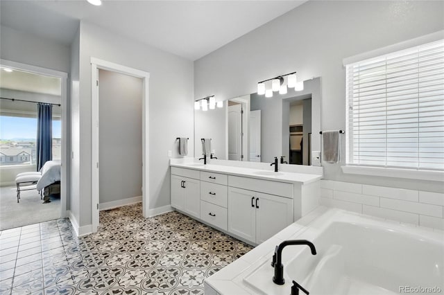 18212 W 95th Pl, Arvada, CO 80007 - ensuite bathroom featuring a garden tub, double vanity, and baseboards