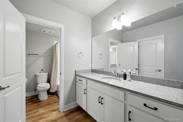 18212 W 95th Pl, Arvada, CO 80007 - full bath featuring wood finished floors, toilet, vanity, baseboards, and shower / tub combo