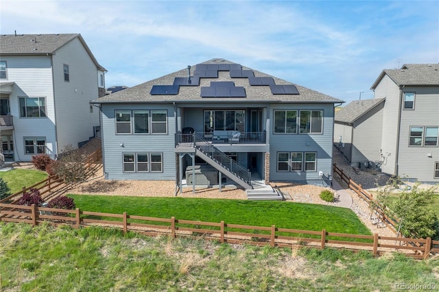 18212 W 95th Pl, Arvada, CO 80007 - back of house with stairs, solar panels, a deck, and roof with shingles