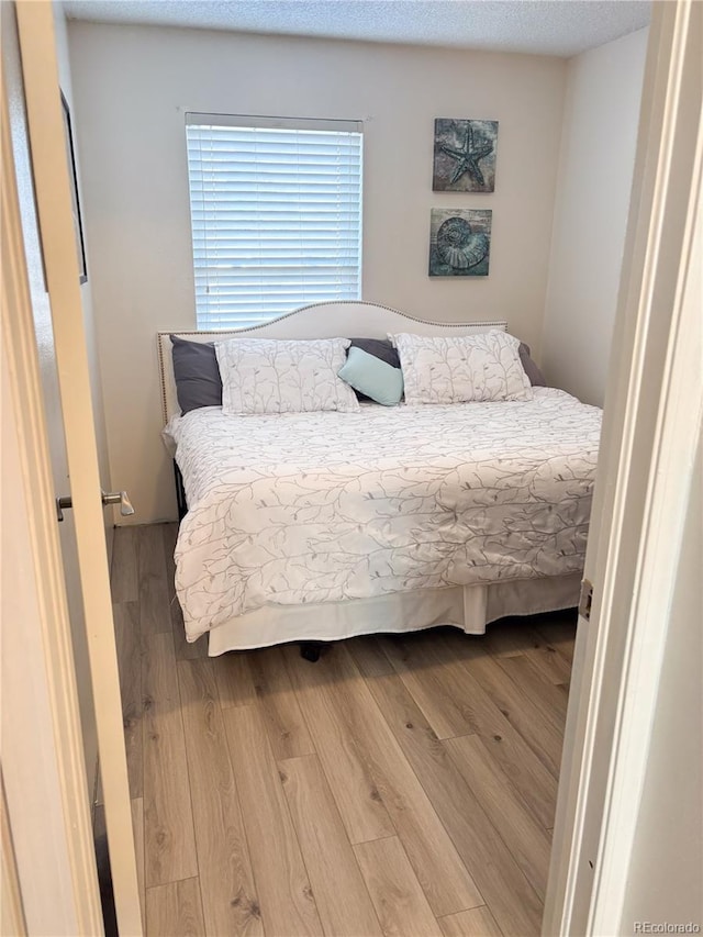 bedroom featuring hardwood / wood-style floors and a textured ceiling