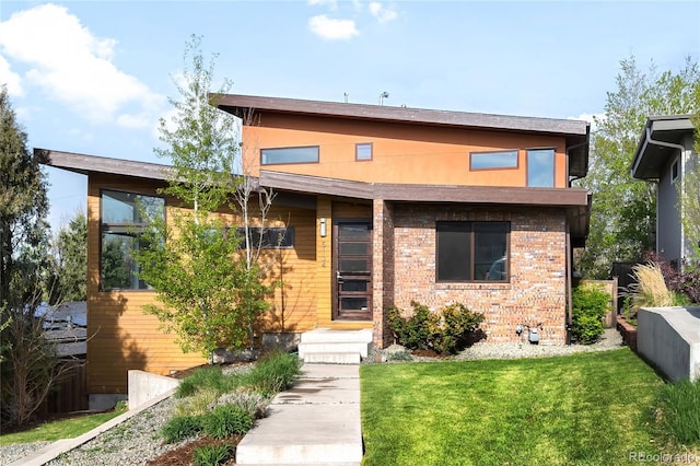 view of front of home with brick siding and a front yard