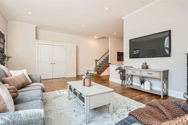 living room with baseboards, stairs, ornamental molding, and wood finished floors