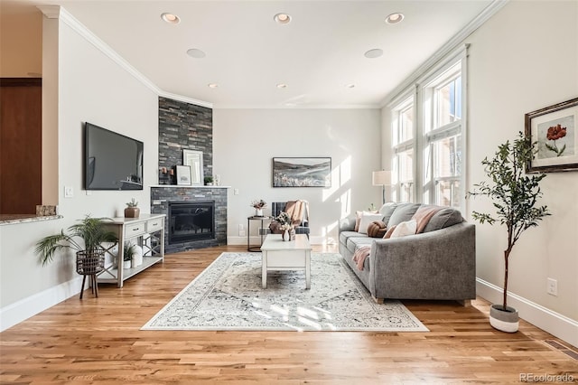 living room with ornamental molding, light wood-type flooring, and a fireplace