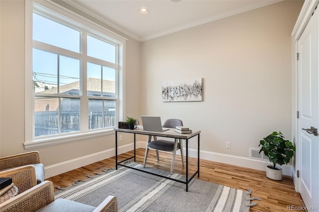 office space featuring light wood finished floors, baseboards, visible vents, ornamental molding, and recessed lighting