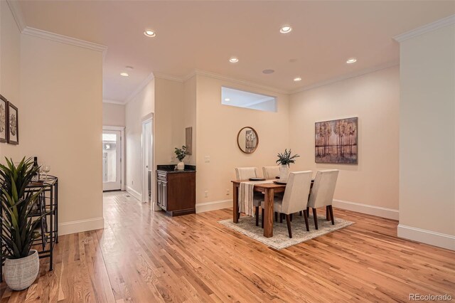 dining room featuring light wood-type flooring, baseboards, ornamental molding, and recessed lighting