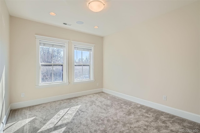 empty room with carpet floors, recessed lighting, visible vents, and baseboards