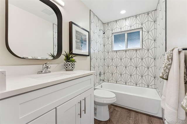 full bathroom with vanity, wood finished floors, visible vents, bathing tub / shower combination, and toilet