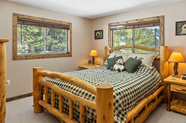 carpeted bedroom with a textured ceiling and baseboards