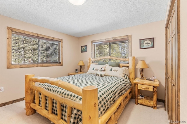 bedroom featuring a textured ceiling, carpet flooring, and baseboards