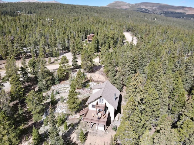 birds eye view of property featuring a mountain view and a view of trees