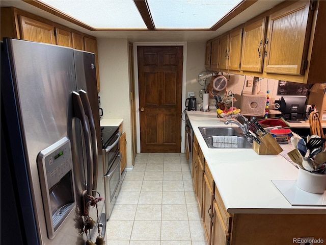 9410 W 89th Cir, Broomfield, CO 80021 - kitchen featuring appliances with stainless steel finishes, brown cabinetry, light tile patterned floors, and light countertops