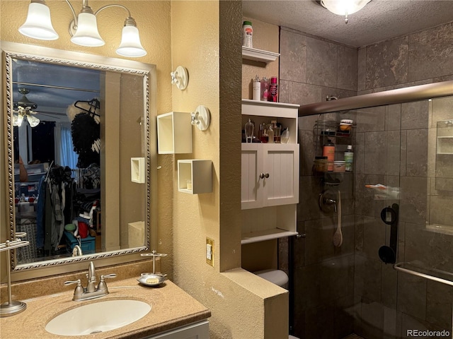 9410 W 89th Cir, Broomfield, CO 80021 - bathroom featuring a textured wall, a stall shower, vanity, a ceiling fan, and a textured ceiling