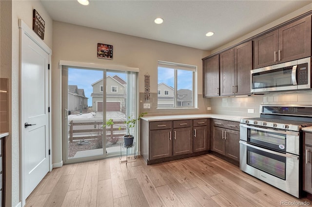 692 Sage Forest Ln, Monument, CO 80132 - kitchen with stainless steel appliances, dark brown cabinets, recessed lighting, and light wood-style flooring
