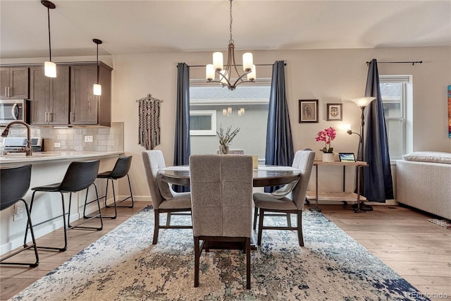 692 Sage Forest Ln, Monument, CO 80132 - dining room featuring a chandelier, plenty of natural light, and light wood finished floors