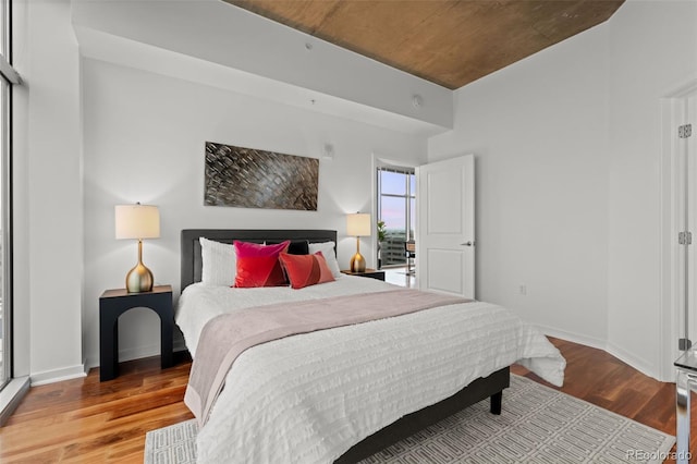 bedroom with wood finished floors and baseboards