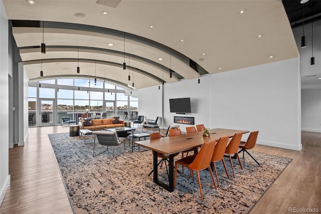 dining room with recessed lighting, lofted ceiling, baseboards, and hardwood / wood-style floors