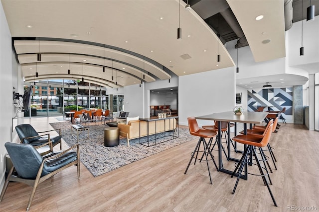 living room with recessed lighting, baseboards, light wood-style flooring, and vaulted ceiling