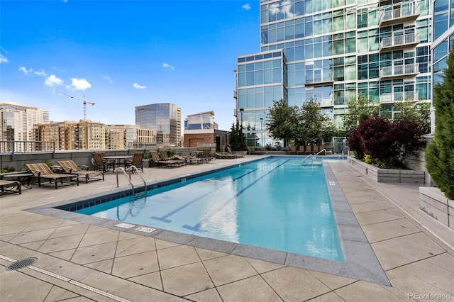 community pool with a view of city and a patio