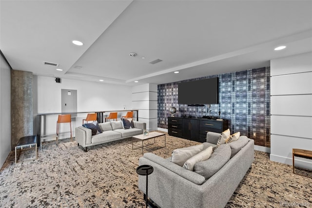 living area featuring visible vents, recessed lighting, baseboards, and a tray ceiling