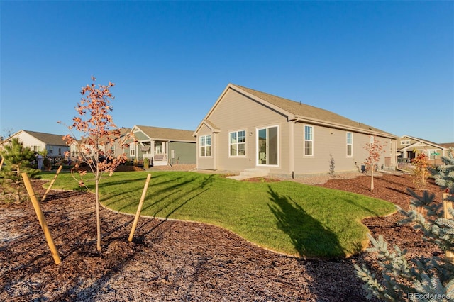 rear view of house featuring a yard