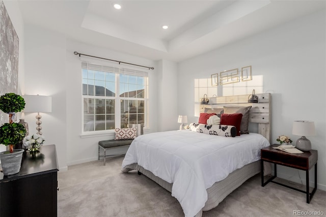 carpeted bedroom featuring a raised ceiling