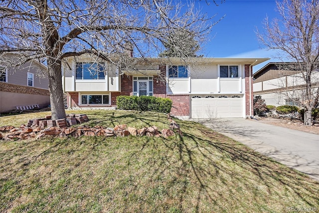 split foyer home featuring a front lawn, an attached garage, brick siding, and driveway