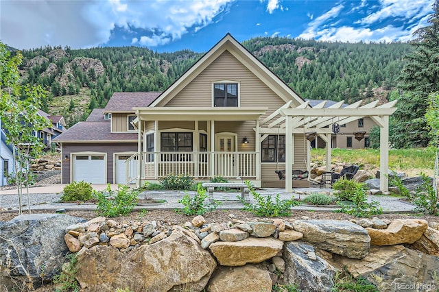 view of front facade featuring a garage, covered porch, and a pergola