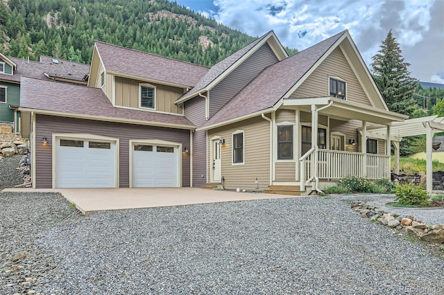 view of front of home with a garage, a porch, and a mountain view