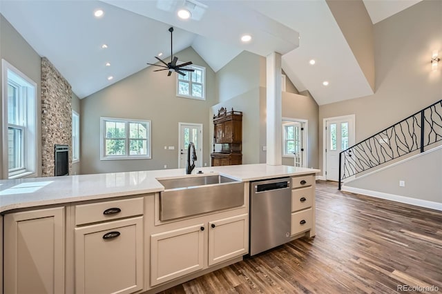 kitchen with dark hardwood / wood-style flooring, stainless steel dishwasher, sink, high vaulted ceiling, and ceiling fan