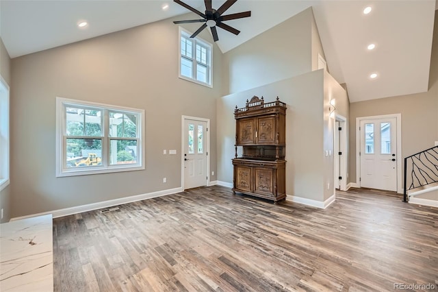 foyer entrance with ceiling fan, hardwood / wood-style floors, and high vaulted ceiling